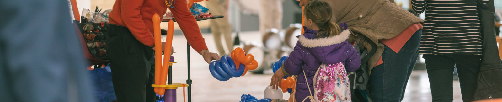 Little girl getting a balloon animal from a friendly clown in Destiny USA mall.