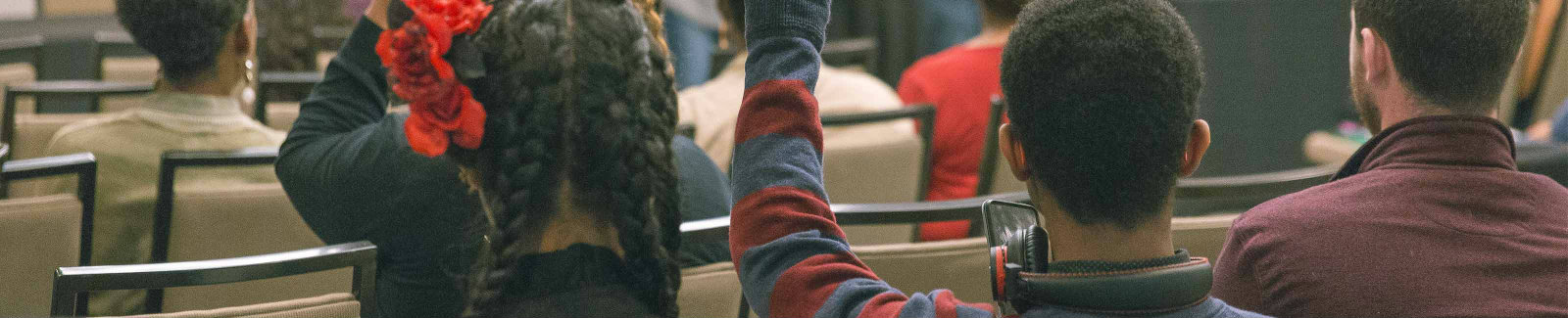 A group of young adults raising their hands at a financial workshop that was hosted by Bankinter S.A.